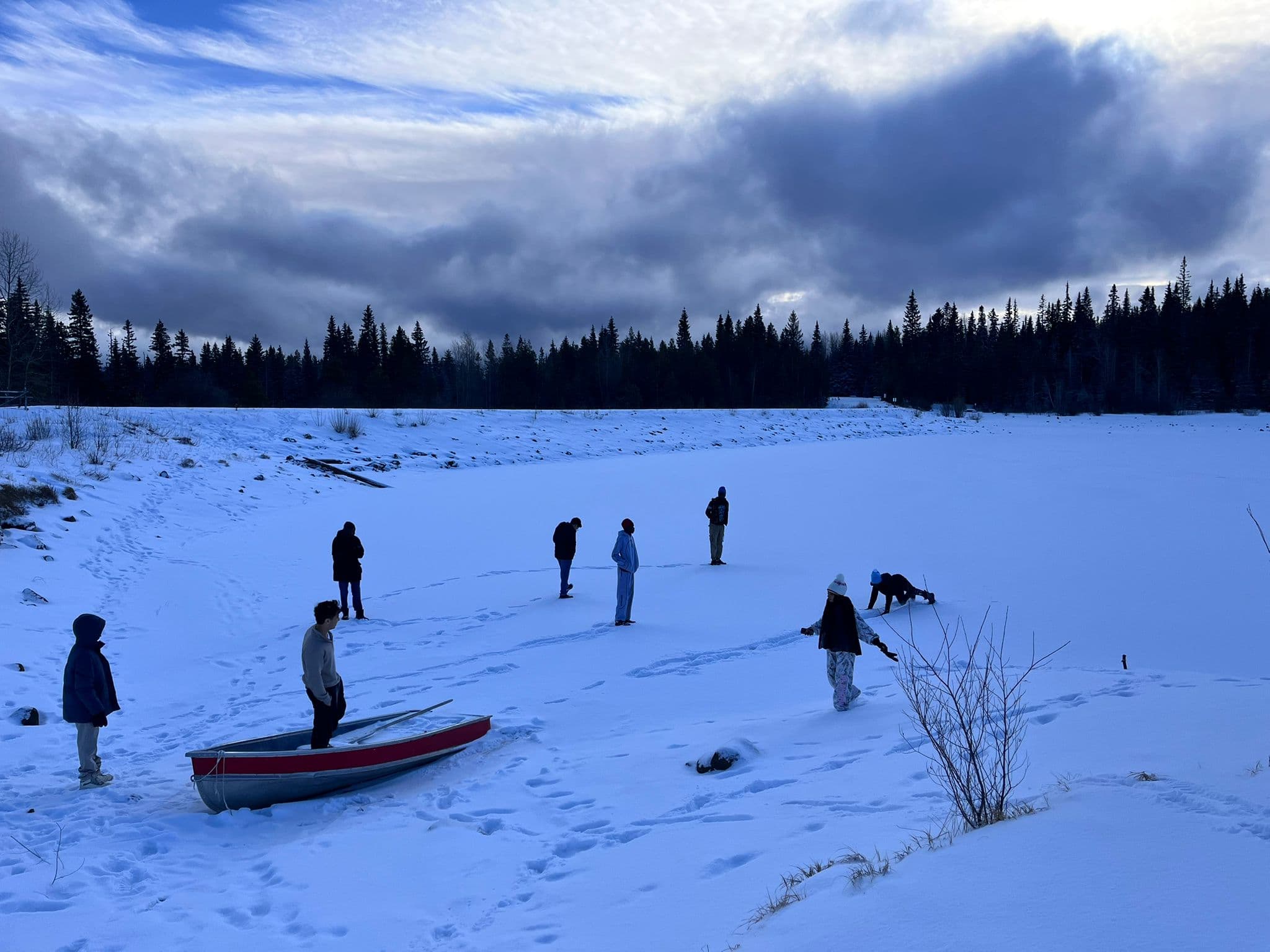 Youth exploring a snowy lakeshore in winter